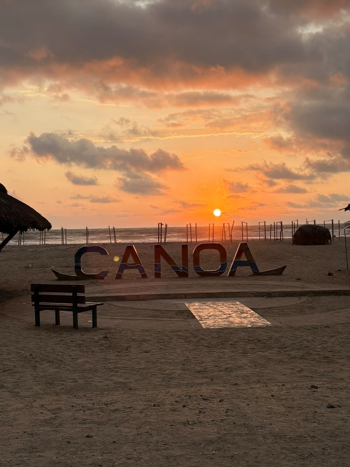 Las letras de Canoa en la playa al atardecer